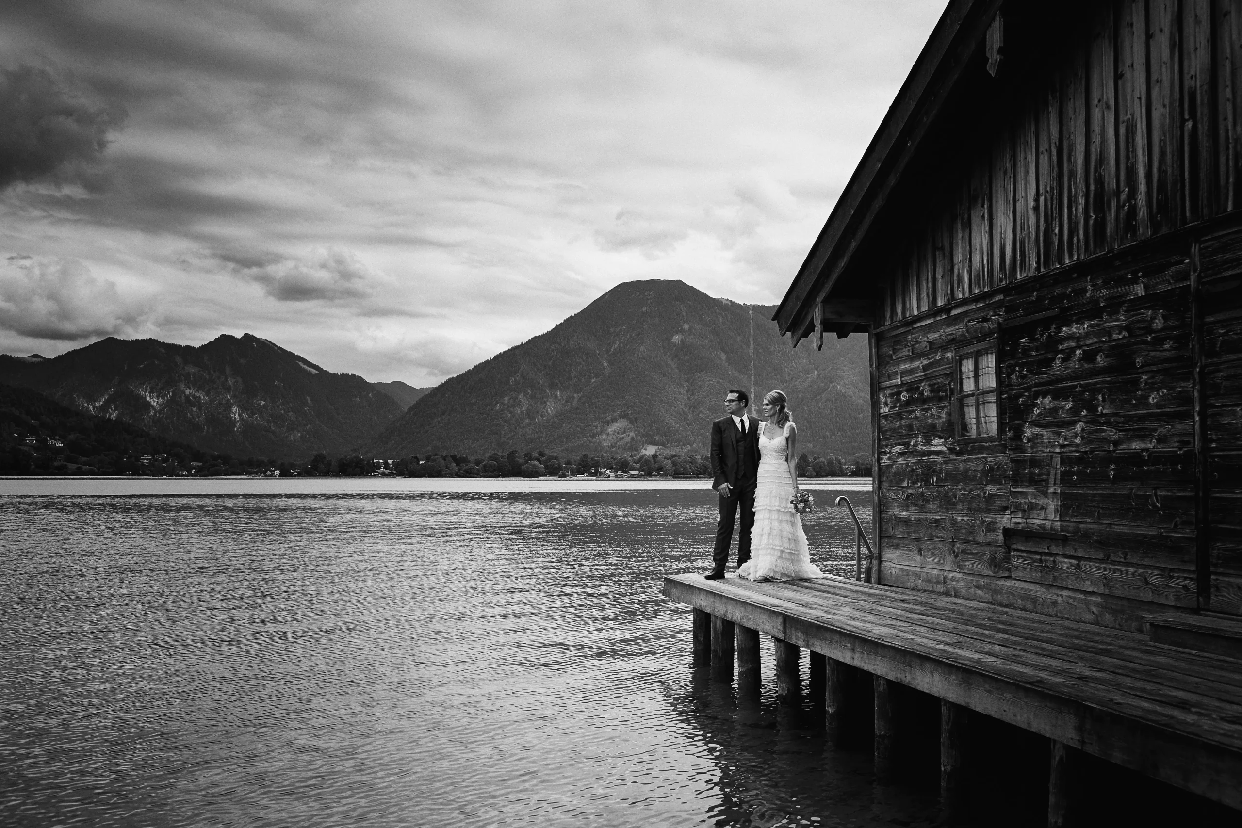 Brautpaar auf einem Steg am Tegernsee bei einer Hochzeit - Hochzeitsplaner Bayern